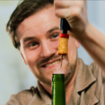 A man opening a wine with the use of a vacuum pump wine opener