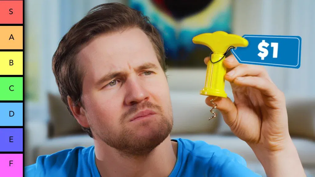 a thumbnail for a YouTube video about a wine opener tier list. A man in a blue T-shirt is holding a $1 yellow opener in his hand.